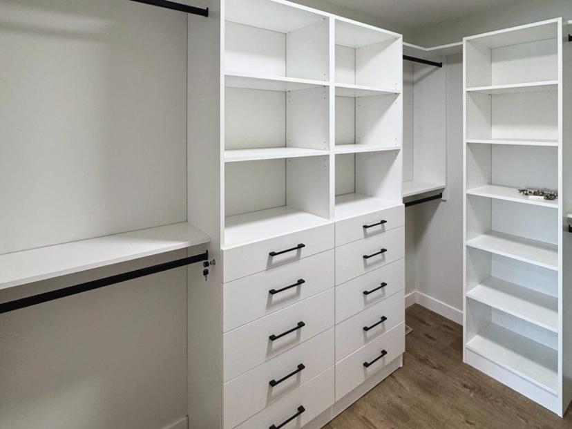 White walk-in closet with open shelving and hanging space.