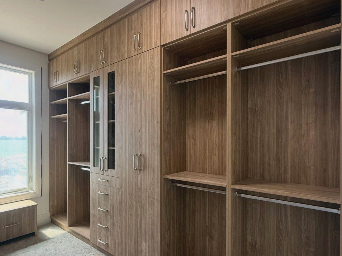 Wood-look closet cabinetry with shelving and hanging space.